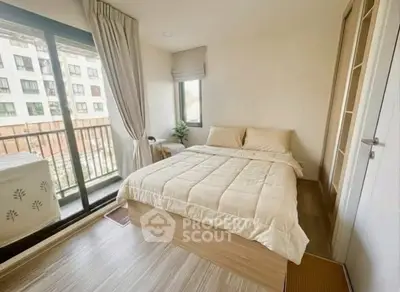 Cozy bedroom with balcony access in modern apartment, featuring a comfortable bed and natural light.