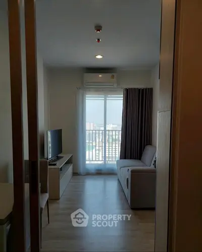 Cozy living room with modern decor and city view from balcony.