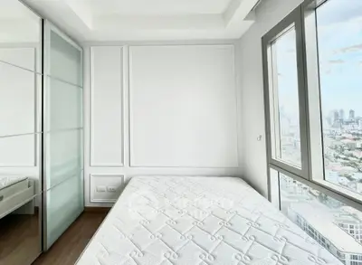 Bright bedroom with city view and modern design in high-rise apartment