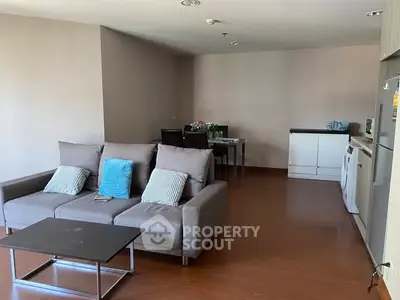 Spacious living room with modern furniture and open kitchen layout, perfect for entertaining.