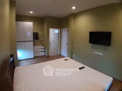 Spacious bedroom with modern furnishings and wall-mounted TV, ideal for comfort and relaxation.