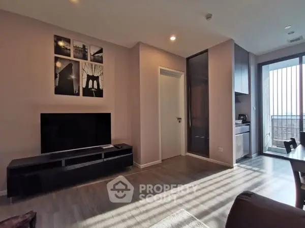 Modern living room with sleek TV setup and balcony view, perfect for urban living.