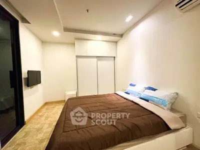 Modern bedroom with cozy bedding and built-in wardrobe in a stylish apartment.