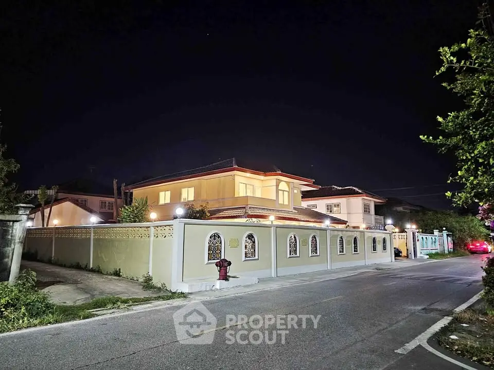 Stunning night view of a luxurious villa with elegant lighting and spacious surroundings.