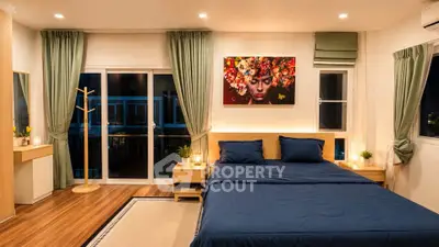 Spacious modern bedroom with elegant decor and large windows for natural light.