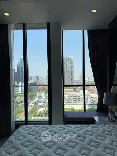 Luxurious bedroom with stunning city view through floor-to-ceiling windows in modern high-rise apartment.