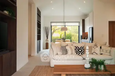 Modern living room with stylish decor and open layout leading to a bright dining area.