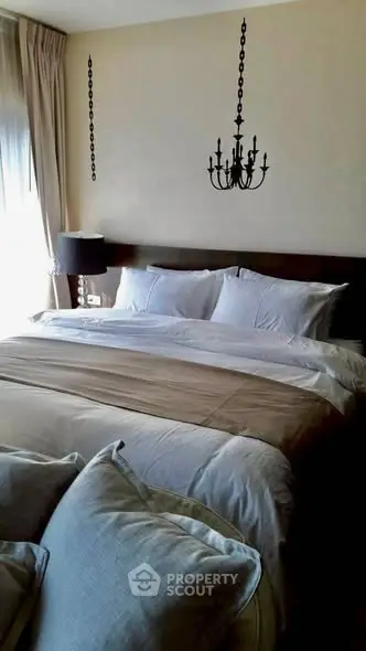 Luxurious bedroom with elegant chandelier and plush bedding