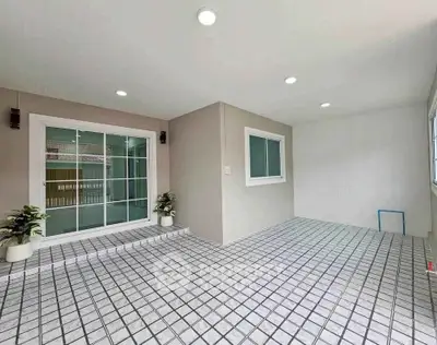 Spacious tiled patio with sliding glass doors and potted plants, perfect for outdoor relaxation.