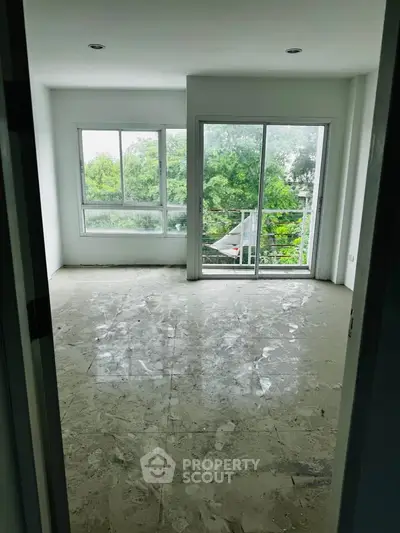 Spacious room with large windows offering lush green views, perfect for natural light lovers.