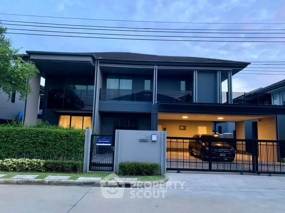Modern two-story house with sleek design and spacious driveway at dusk.