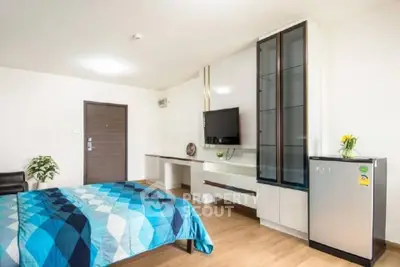 Modern bedroom with stylish decor and compact fridge, perfect for urban living.
