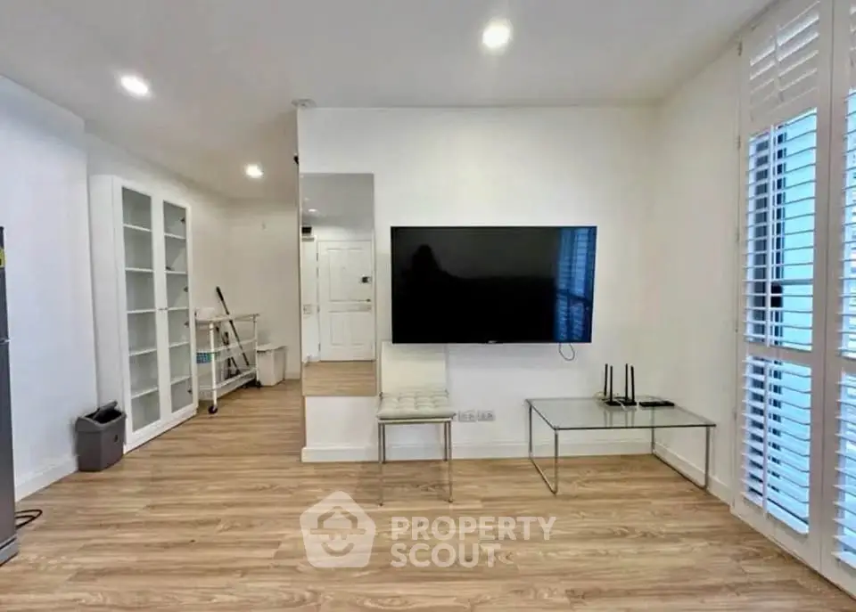 Modern living room with sleek TV setup and wooden flooring