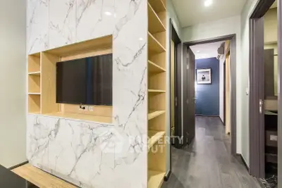 Modern living room with marble TV wall and sleek hallway