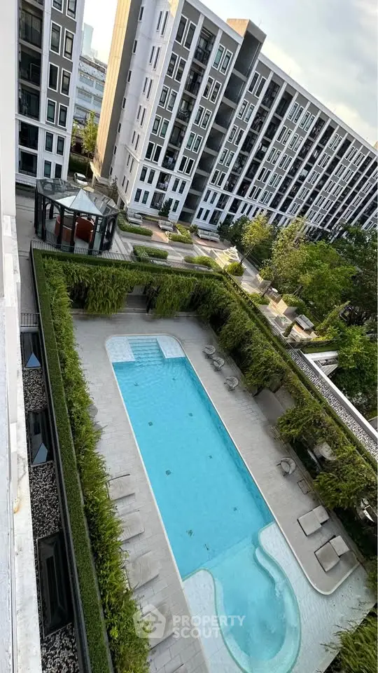 Modern apartment complex with pool and lush greenery, offering a serene urban living experience.