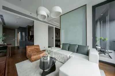 Modern living room with sleek furniture and large windows offering natural light.