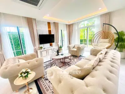 Luxurious living room with elegant furniture and large windows offering garden views.