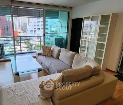 Spacious living room with city view, modern furniture, and large windows in a high-rise apartment.