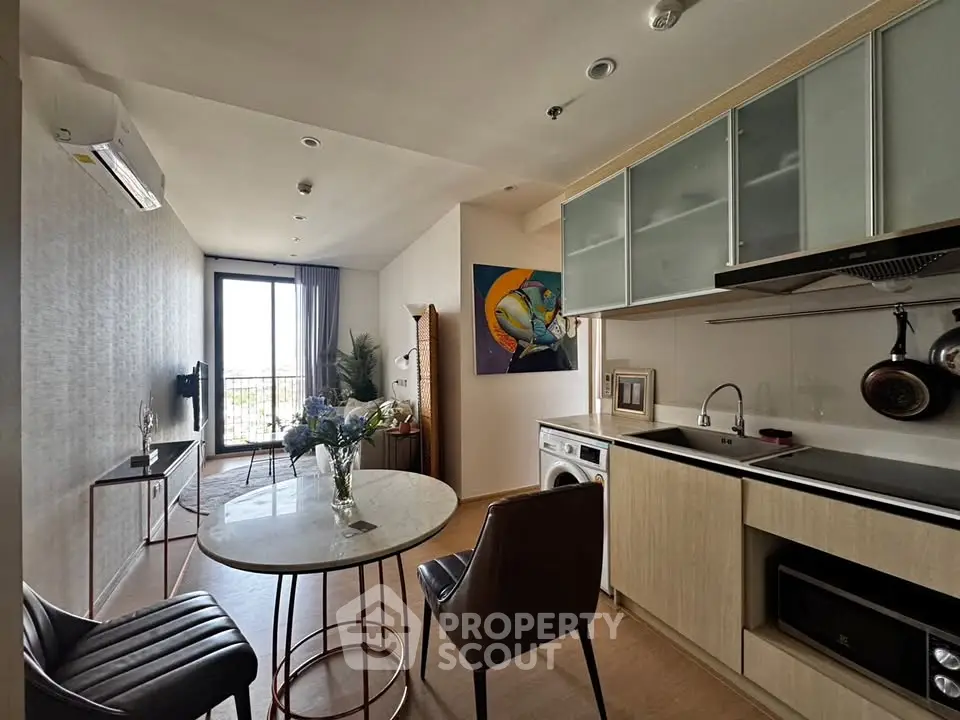 Modern apartment interior with open kitchen and cozy living area, featuring stylish furniture and natural light.
