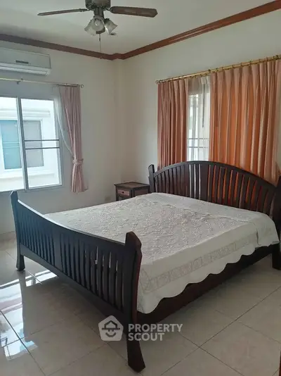 Spacious bedroom with elegant wooden bed and natural light