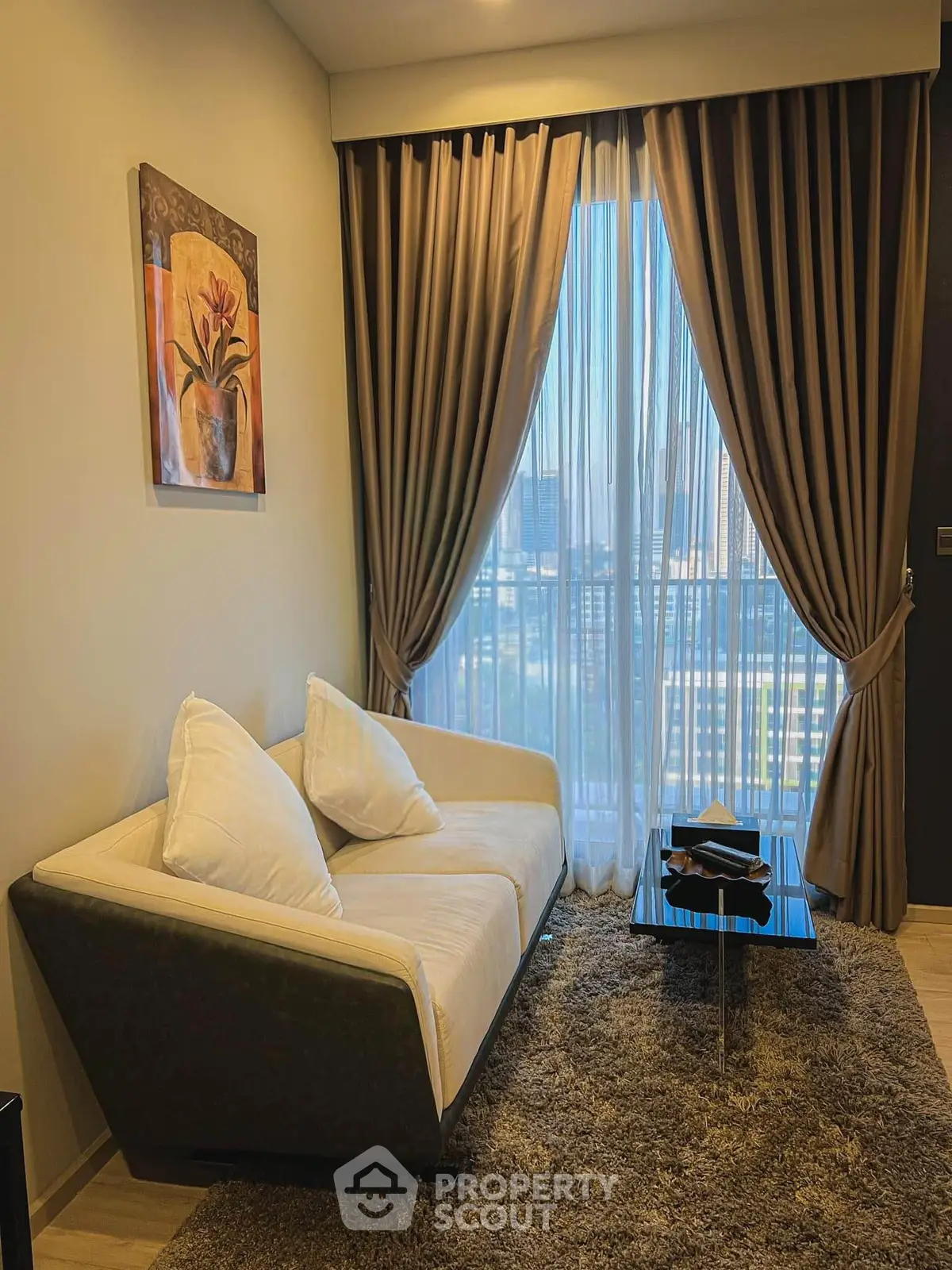 Cozy living room with elegant decor and city view through large window.