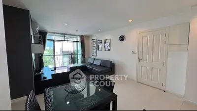 Modern living room with sleek black furniture and balcony view