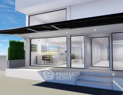 Modern commercial property with sleek glass facade and inviting entrance, perfect for a cafe or retail space.