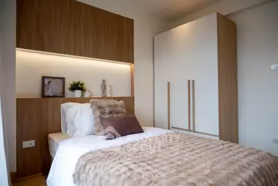 Cozy modern bedroom with stylish decor and ample storage space.