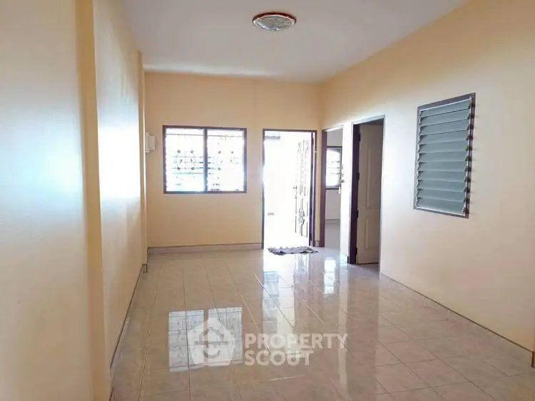 Spacious empty room with tiled floor and natural light, ideal for customization.