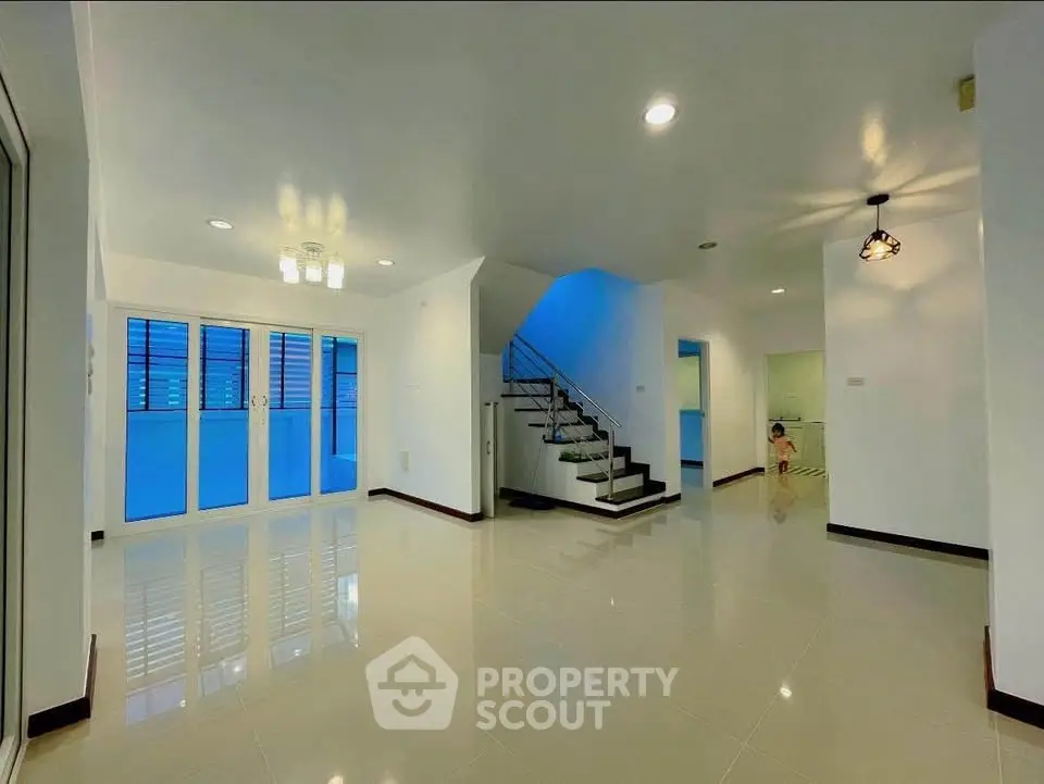 Spacious modern living room with staircase and large windows