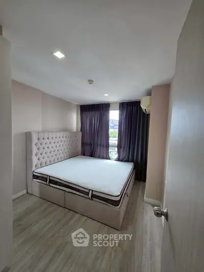 Spacious bedroom with elegant decor and large window for natural light