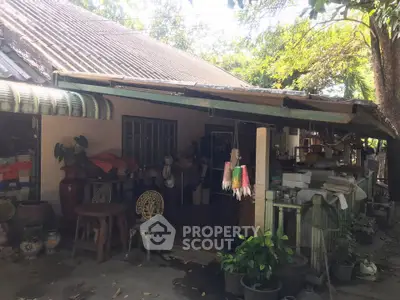 Charming rustic house with lush greenery and cozy outdoor seating area.