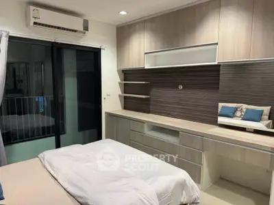 Modern bedroom with built-in storage and balcony access in stylish apartment.