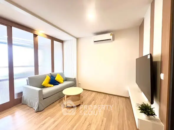 Modern living room with sleek design, featuring a cozy sofa, stylish TV setup, and elegant wooden flooring.