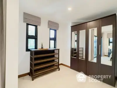 Spacious bedroom with mirrored wardrobe and natural light