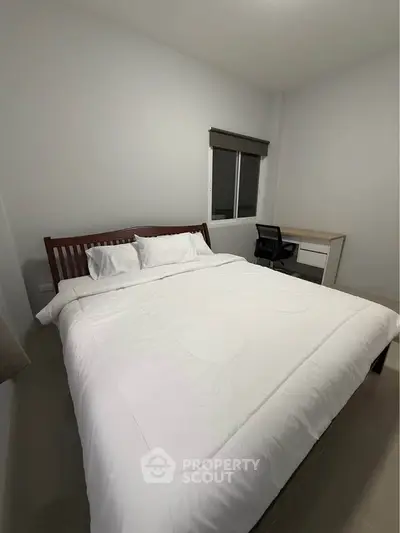 Cozy bedroom with modern desk and comfortable bed in minimalist style.