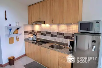 Charming kitchen with modern appliances, ample wooden cabinetry, and stylish tiled backsplash, perfect for culinary enthusiasts.