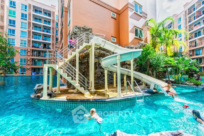 Luxurious apartment complex with stunning pool and water slide, perfect for family living.