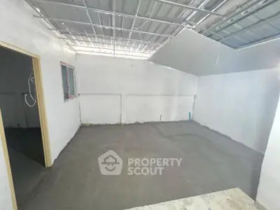 Spacious unfinished room with concrete floor and metal ceiling, ideal for customization.