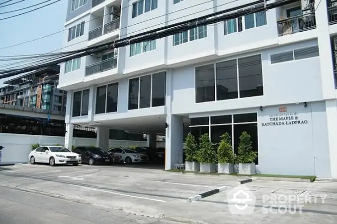 Modern apartment building exterior with parking area and sleek design