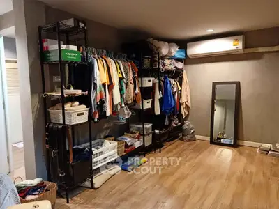 Spacious walk-in closet with organized shelving and modern air conditioning unit.