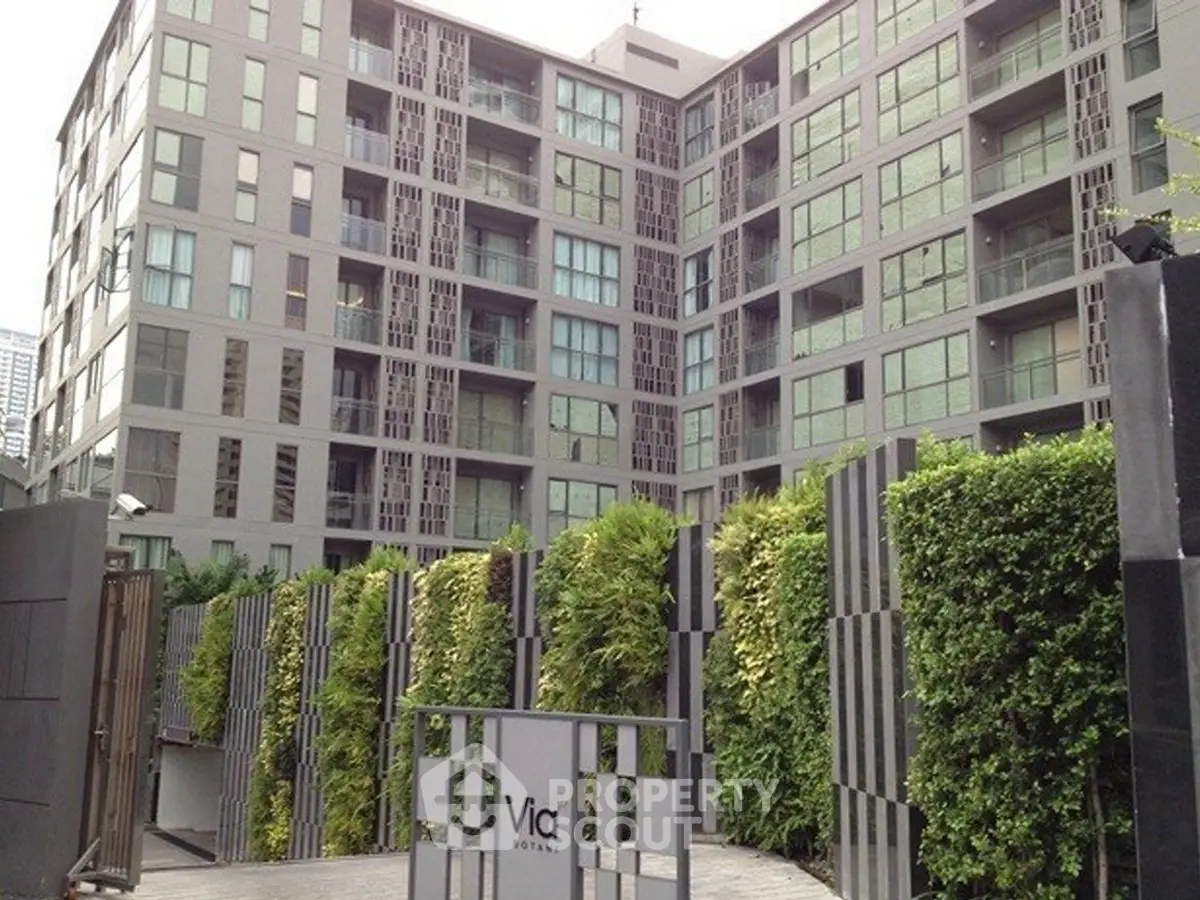 Modern urban condominium with lush greenery and sleek architectural design.