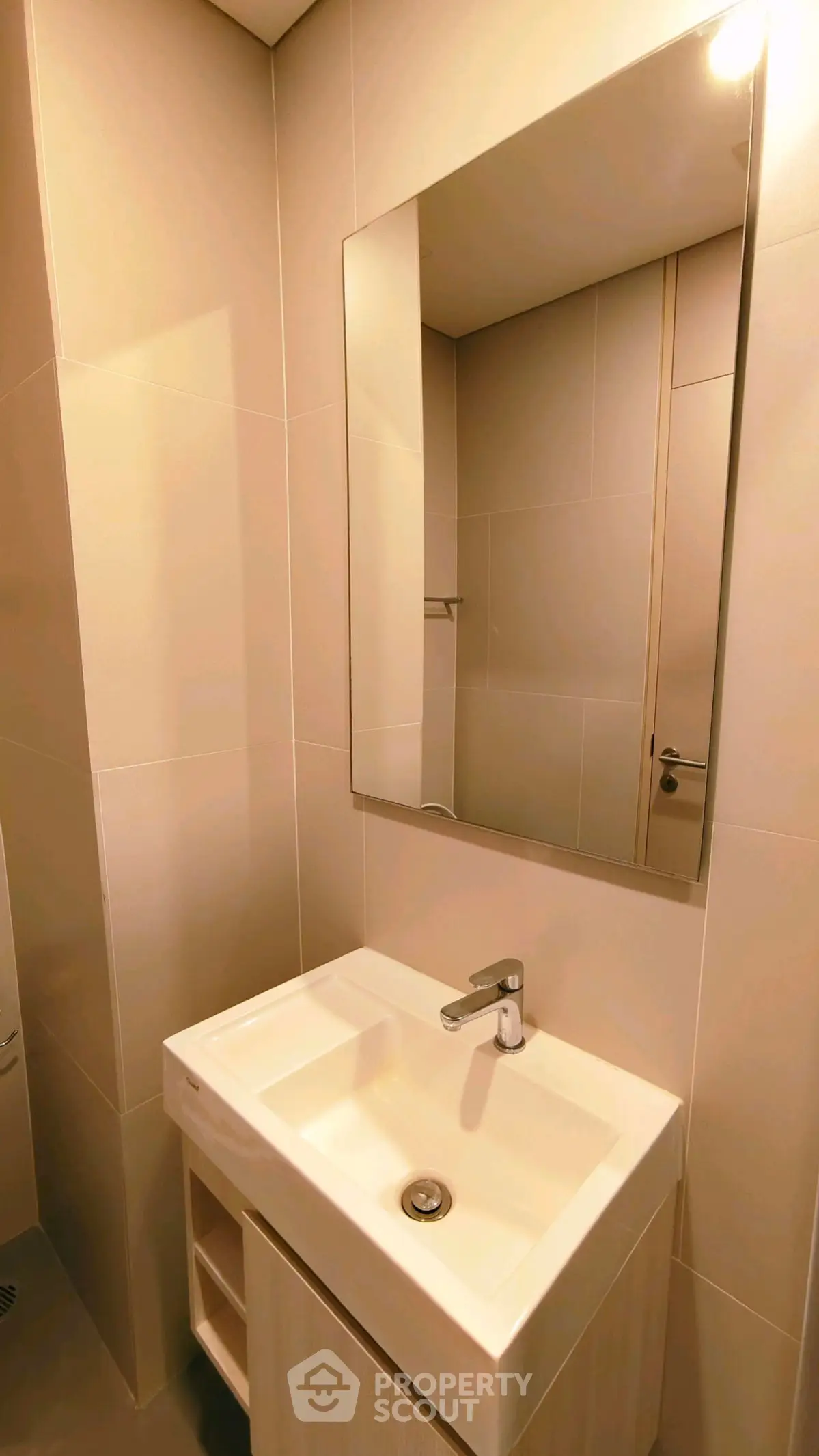 Modern bathroom with sleek sink and large mirror in minimalist design.