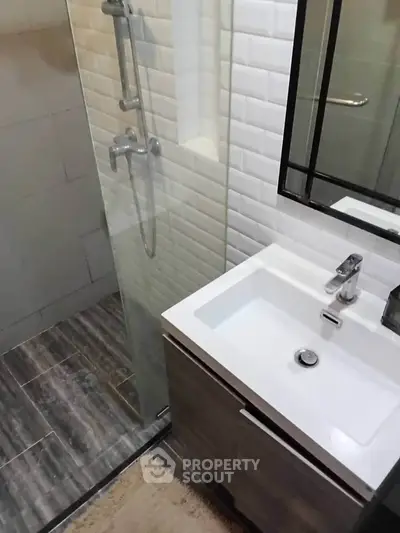 Modern bathroom with sleek shower and stylish vanity in contemporary apartment.