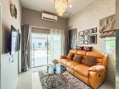 Stylish living room with leather sofa, modern decor, and large sliding glass doors opening to a patio.