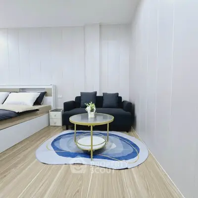 Modern bedroom with stylish decor, featuring a cozy bed, elegant sofa, and chic coffee table on a designer rug.