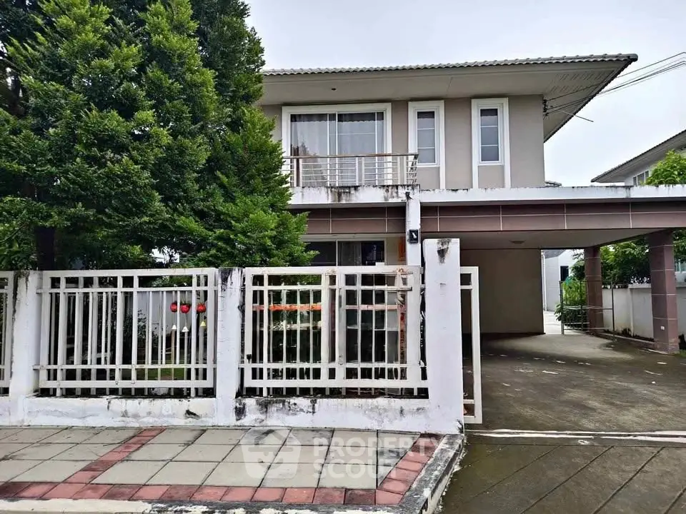 Charming two-story house with spacious driveway and lush greenery, perfect for family living.
