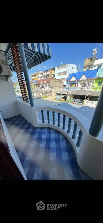 Charming balcony with vibrant city view and colorful architecture.