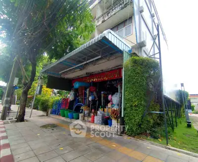 Charming corner shop with lush greenery and street view, ideal for small business opportunities.