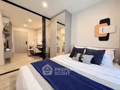 Modern bedroom with stylish decor and sliding glass doors leading to a cozy study area.